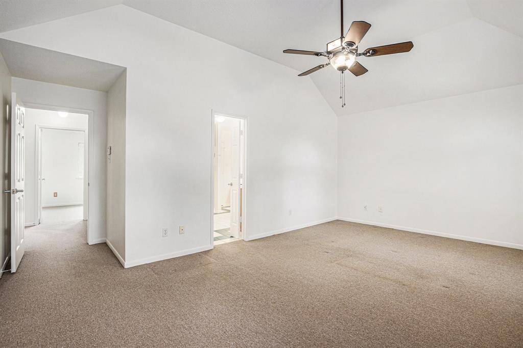 Upstairs PRIMARY bedroom, complete with high ceilings and ceiling fans.