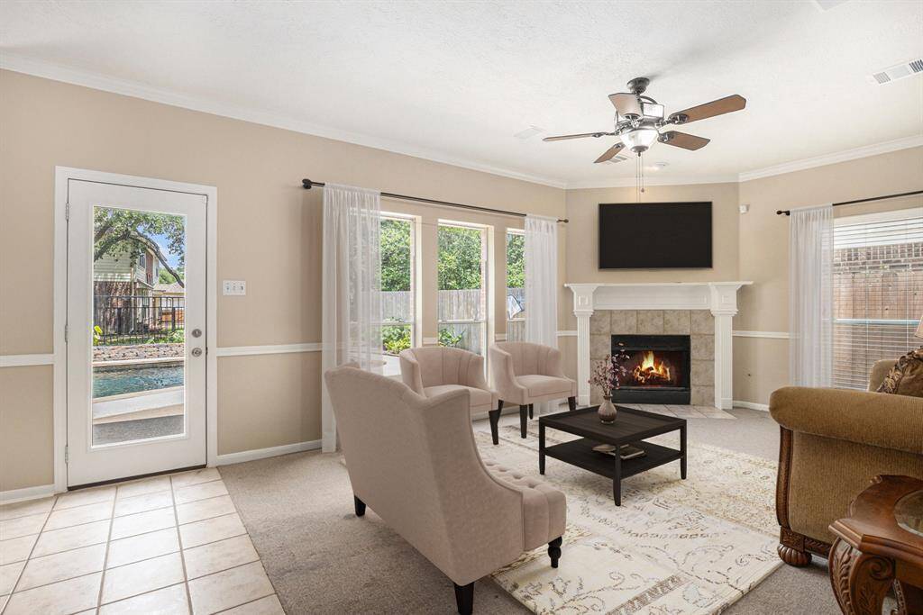 This is the Informal living area/den right off the kitchen. Notice the corner fireplace, ceiling fan, and view! Virtually staged