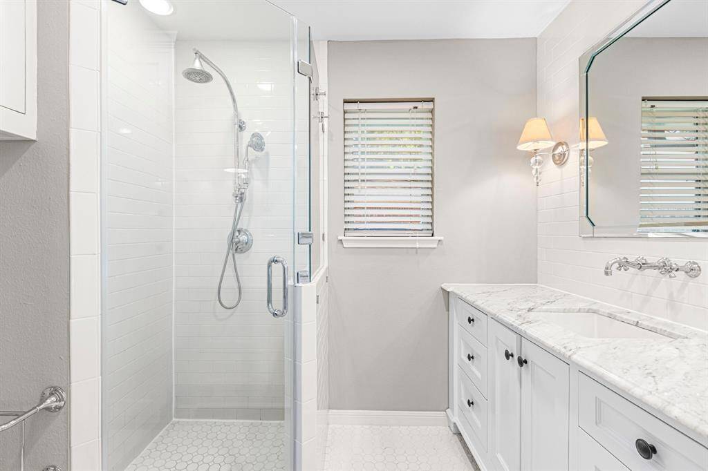 PRIMARY BATHROOM - Updated walk in shower with stunning countertops and plenty of storage space.