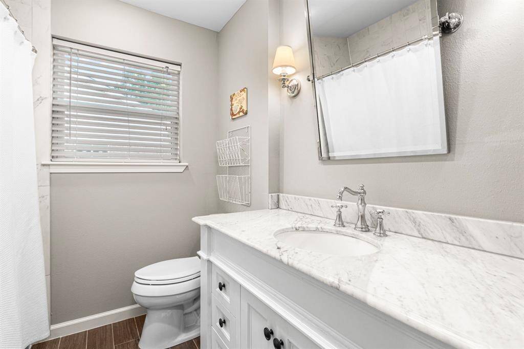 SECONDARY BATHROOM- Marble counters and floating mirror. Shower/tub combo.