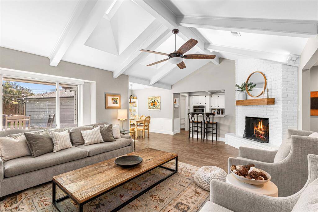 LIVING ROOM - Open to the kitchen and breakfast room, anchored by a beautiful white brick fireplace. Vaulted ceilings give this room such a nice, open feel.