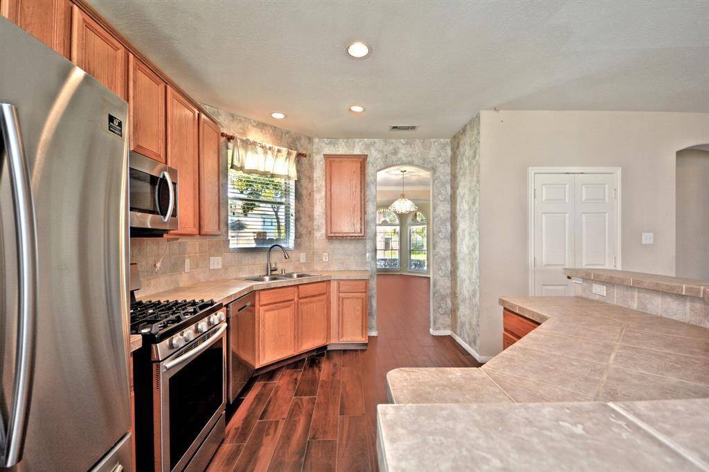 The kitchen features stainless steel appliances, a spacious layout, and French doors that open to a large walk-in pantry, providing plenty of room for all your storage needs.