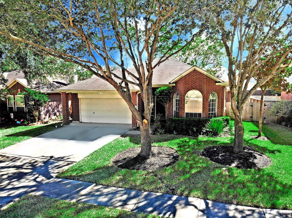 The garage features a portico that helps keep it shaded during hot summer days, complemented by a full sprinkler system and mature trees that enhance both comfort and curb appeal.