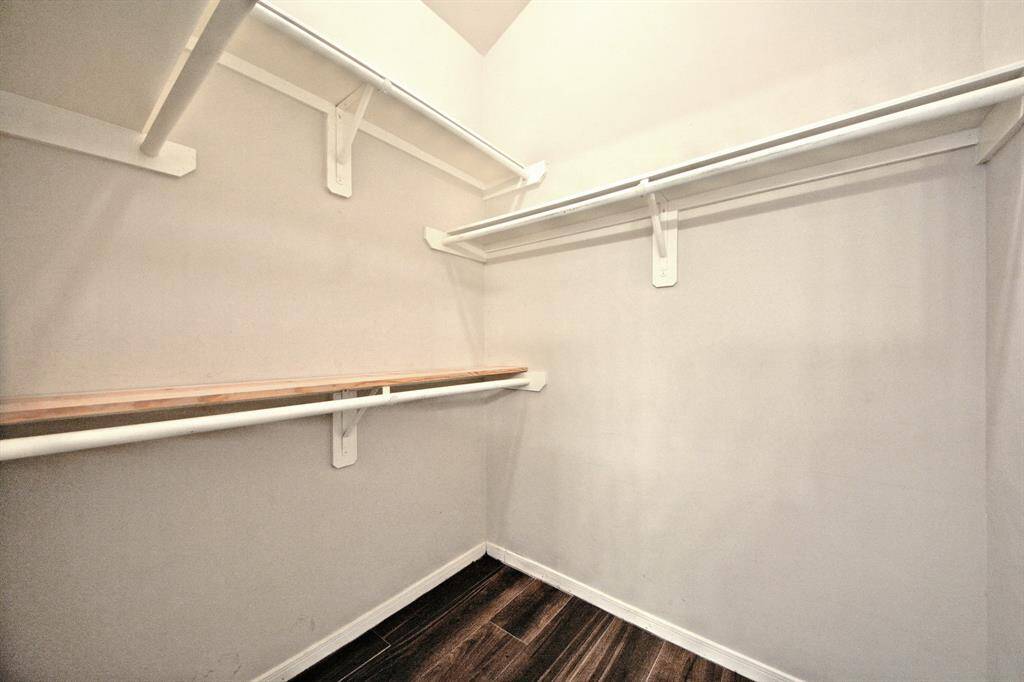 The primary suite includes a spacious walk-in closet with built-in shelving and plenty of room to keep everything organized and easily accessible.