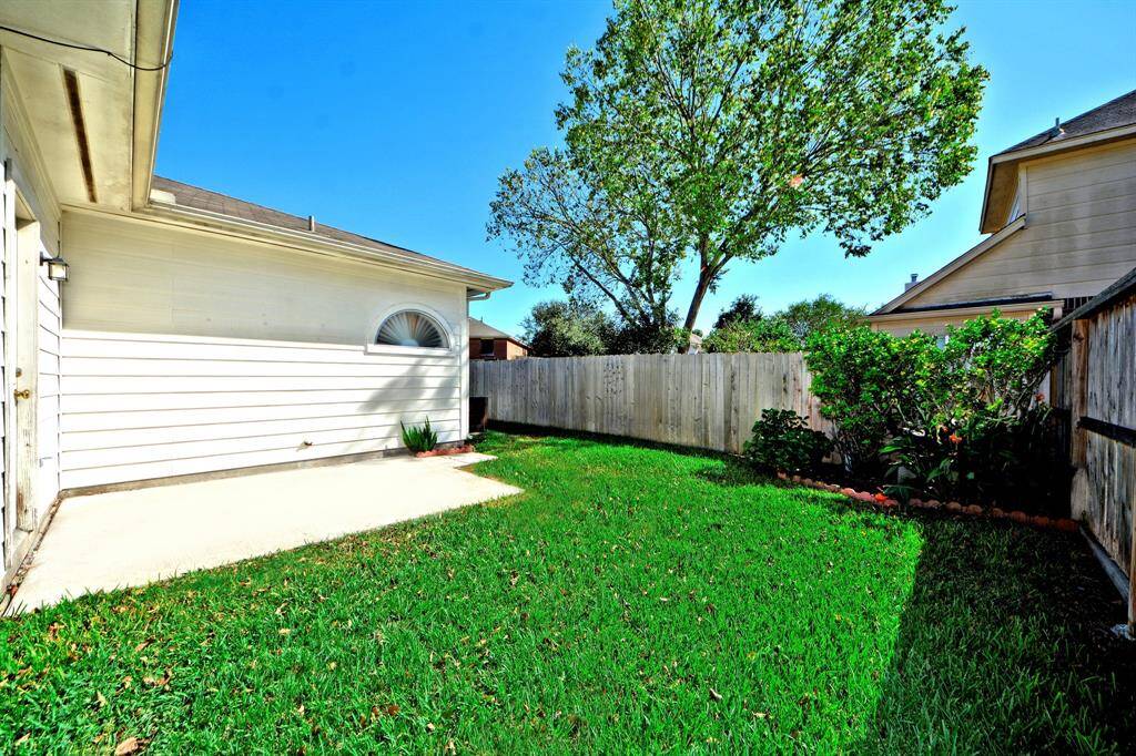 The backyard includes a patio area and extra green space—ideal for relaxing, entertaining, or letting pets roam freely.
