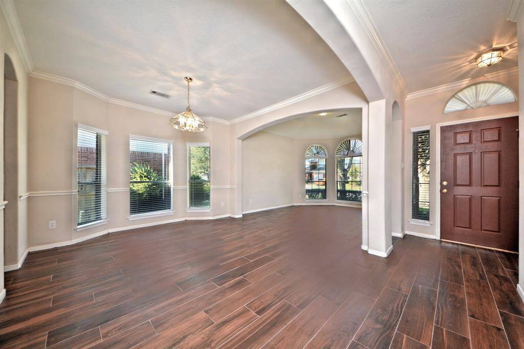The formal dining area provides the perfect setting for gatherings, highlighted by high ceilings, crown molding, and large windows that bring in natural light.
