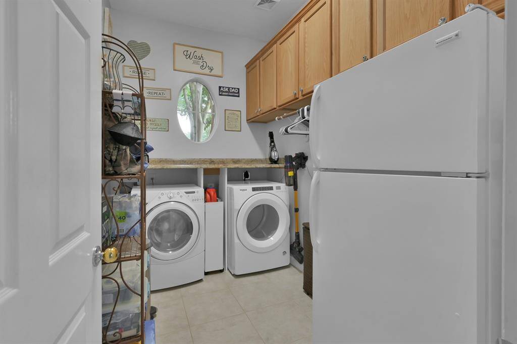 Located on the first floor is this large laundry room with space for a second refrigerator.  Check out all of those cabinets!