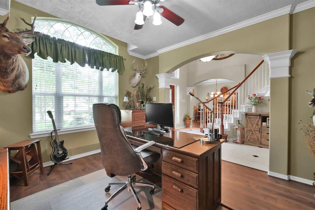 Another view of the study with an arched doorway and crown molding.