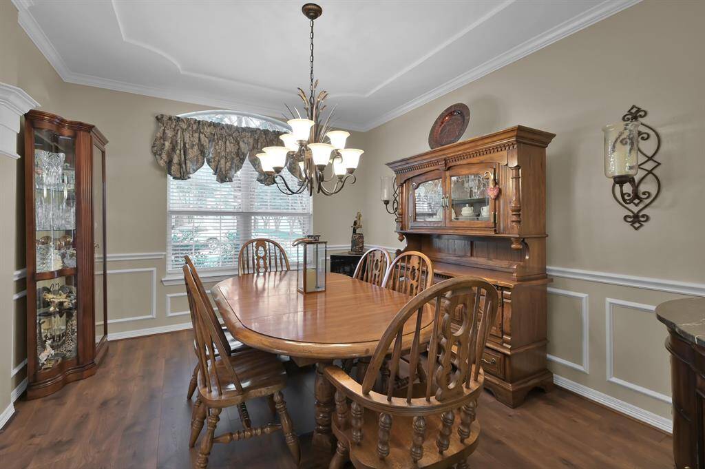 On the opposite side of the entry is this formal dining room. There is a decorative ceiling and wainscoting which add to the custom feel of the home.