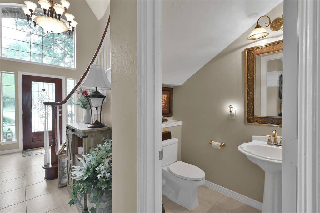 Tucked under the staircase off the entrance is this half bath with pedestal sink. Convenient for guests!