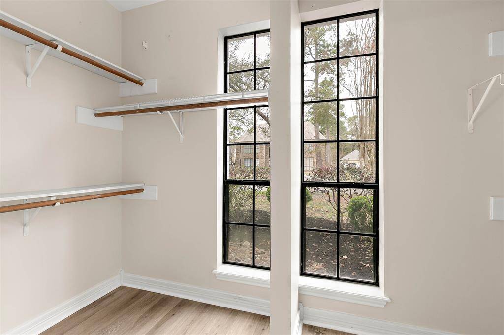 Spacious closet in primary bedroom with large windows.