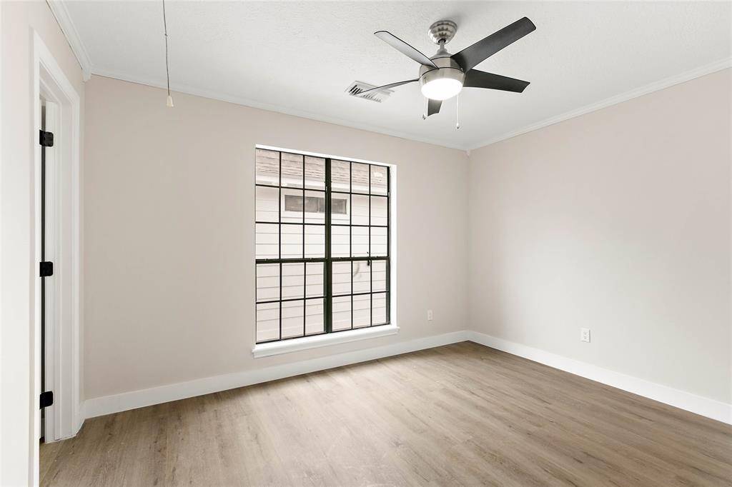 Upstairs bedrooms feature neutral paint palette, large windows with grid detailing and ceiling fans.