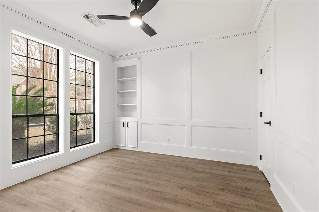 Offering a versatile space suitable for an office/study or second bedroom down, this bright room is accented with large windows, built-in shelving, and a closet. Features modern ceiling fan and elegant moulding.