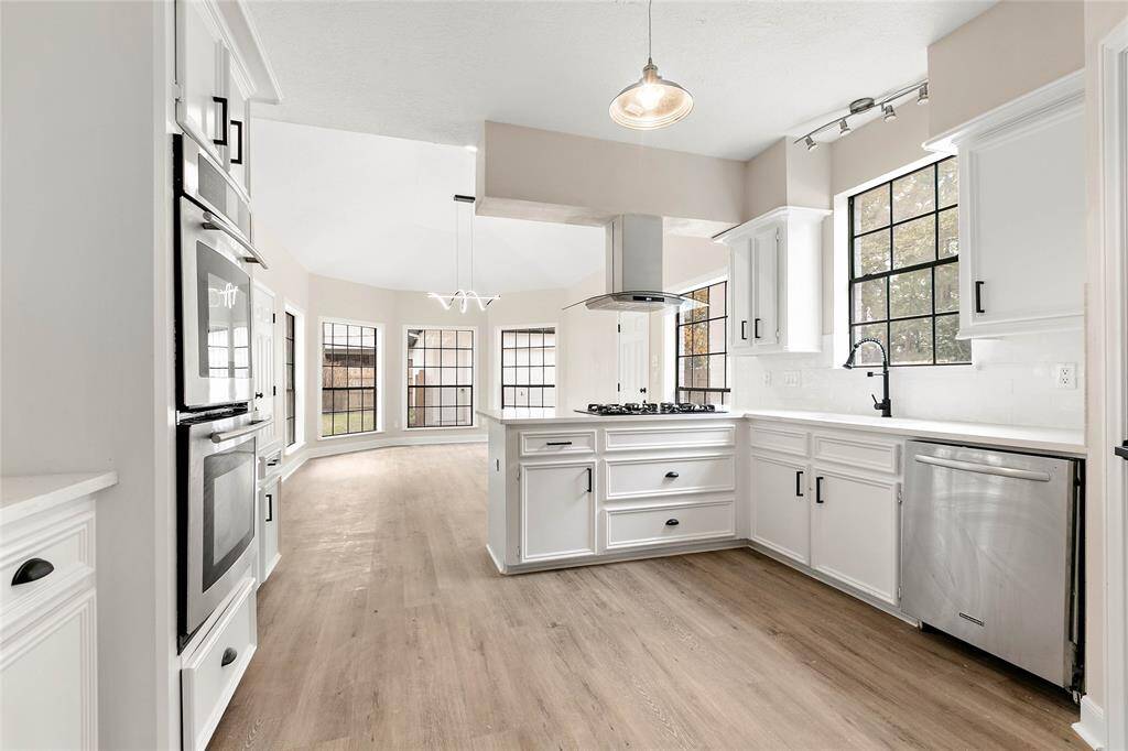 Completely updated modern kitchen with white cabinetry and stainless steel appliances.