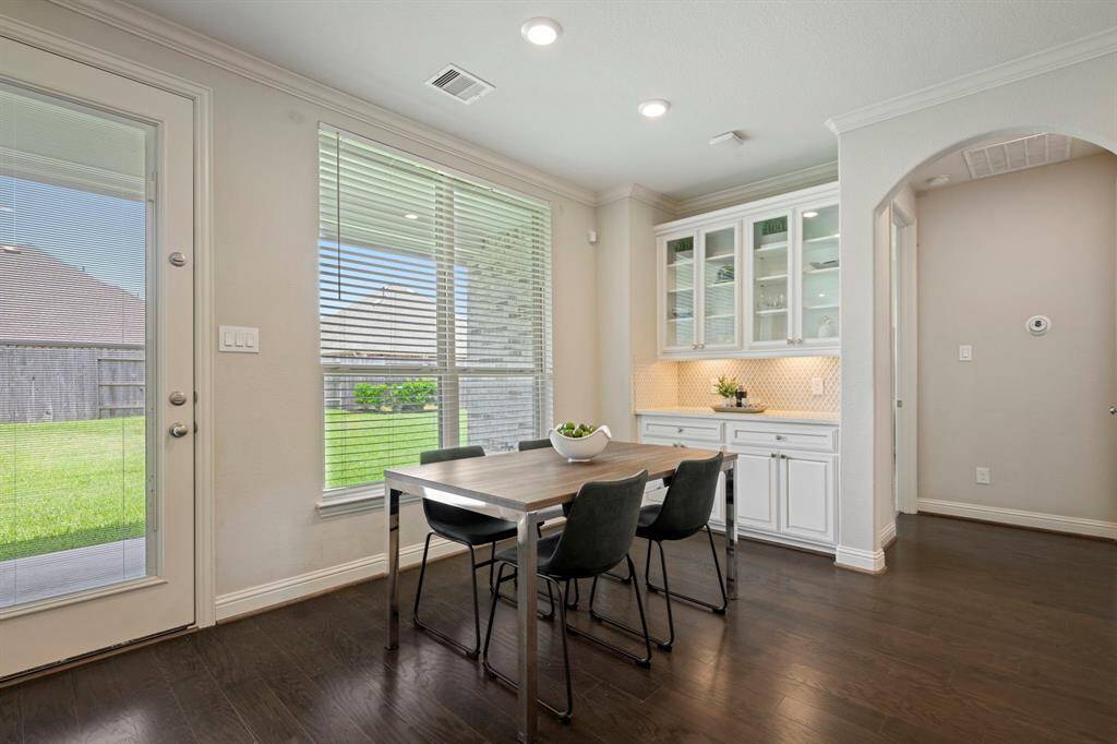 Bright breakfast area with large windows and a view of the backyard. Easy access to the patio through the glass door.