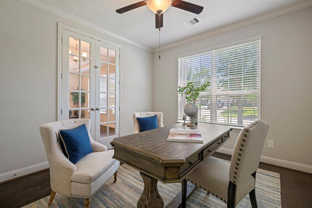Inviting home office with a large window and french doors.