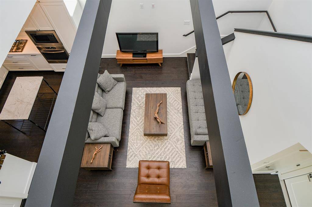 From the upstairs landing, you can see the height of the open living room and the beautiful accent of the suspended wood beams.