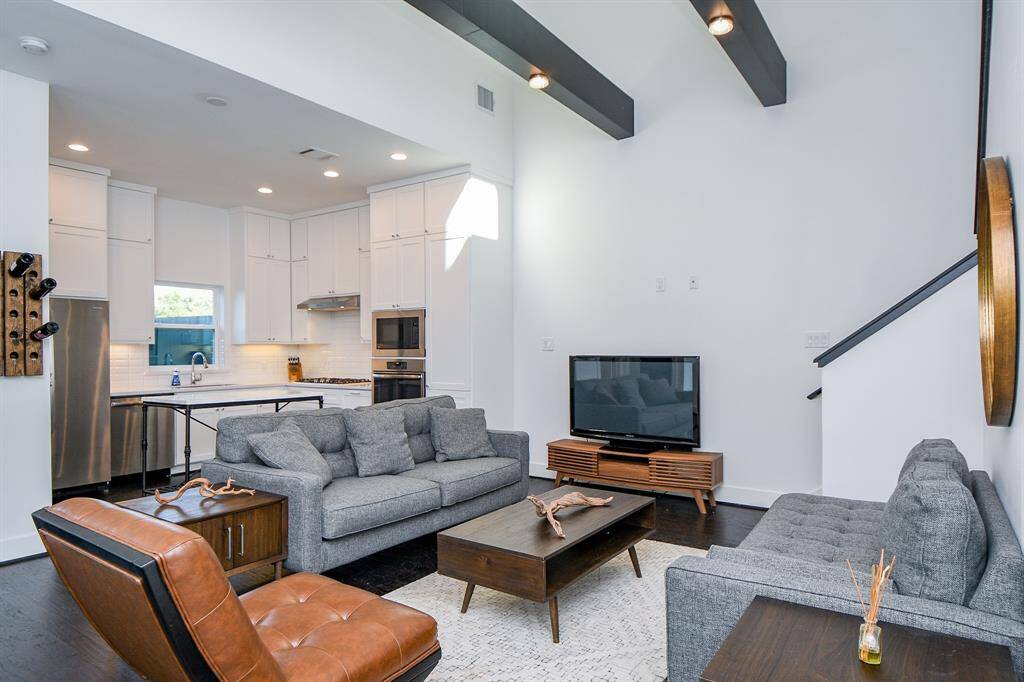 The spatial living room has extremely high ceilings and beautiful lowered beams giving a majestic feel as you walk in.