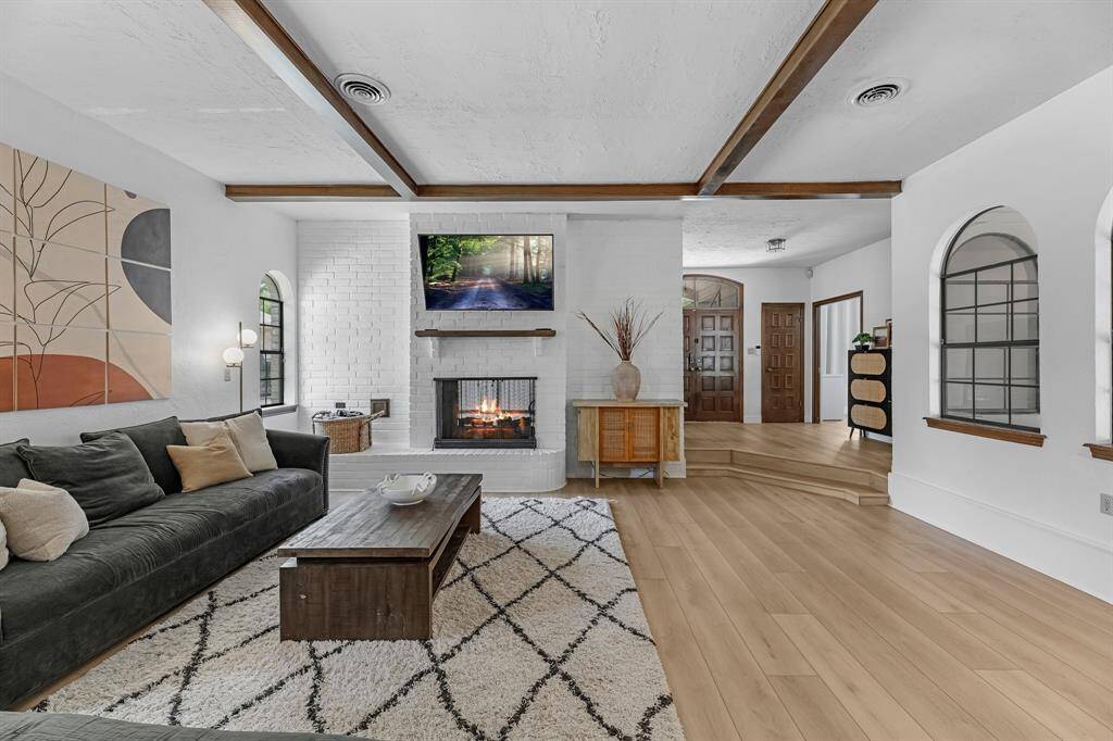 Cozy living room with a fireplace and exposed beams.