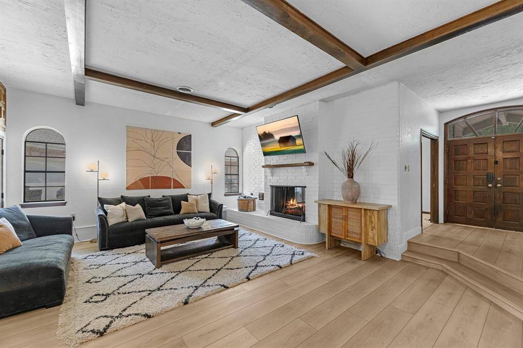 Gather in this beautifully updated living space with new flooring, wood-beamed ceilings, and plenty of room to relax. The shared double-sided fireplace adds a touch of luxury and warmth to every occasion.