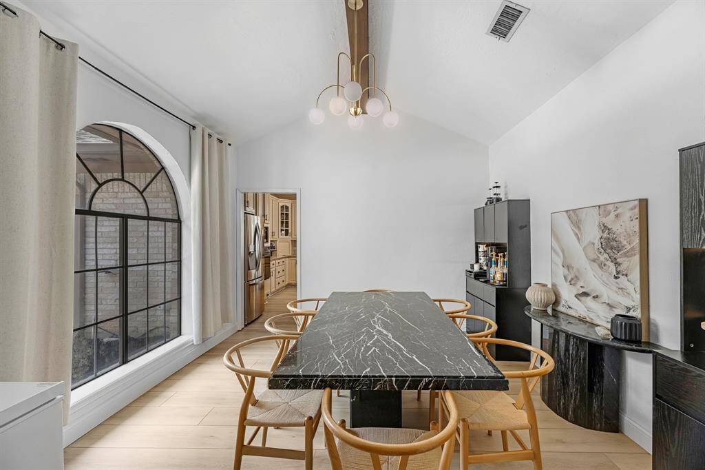 Featuring modern lighting, and a stunning arched window that fills the space with natural light. This stylish dining area flows seamlessly into the kitchen, perfect for entertaining.
