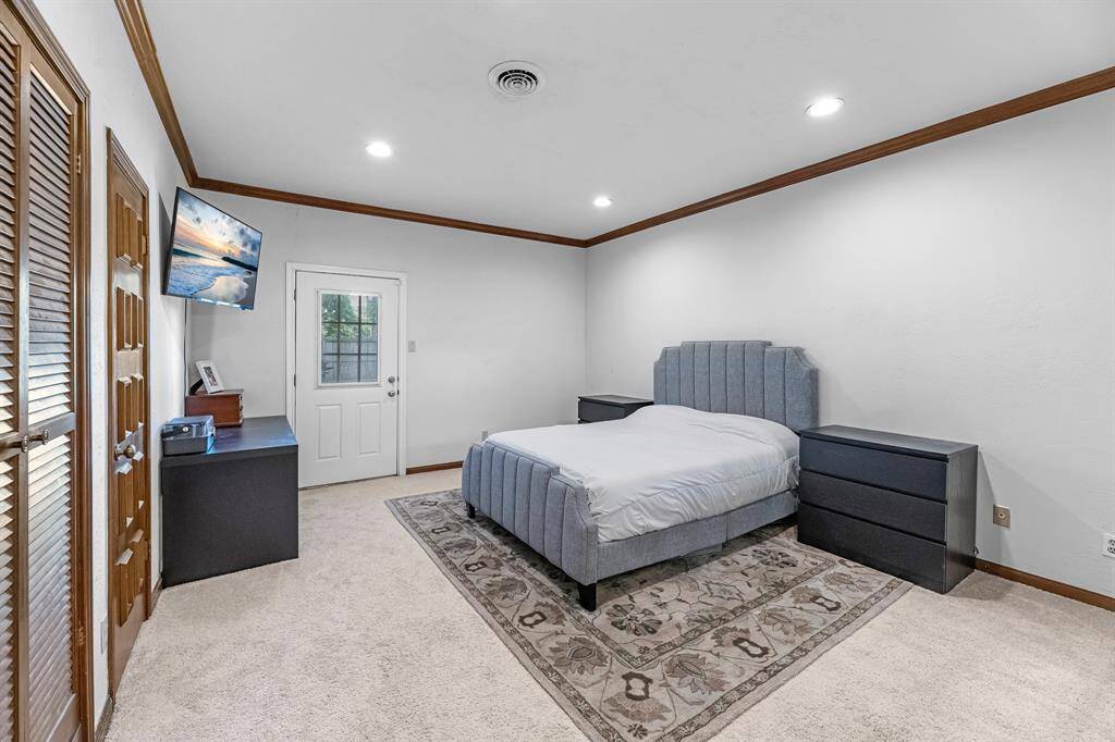 Large primary space with outdoor access and crown molding.