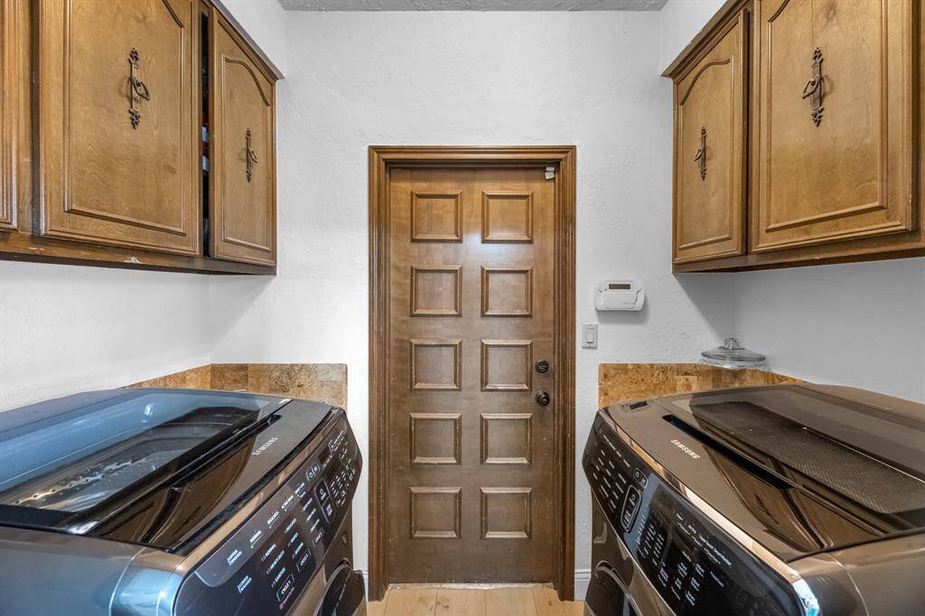Separate laundry room with cabinets and exterior access.
