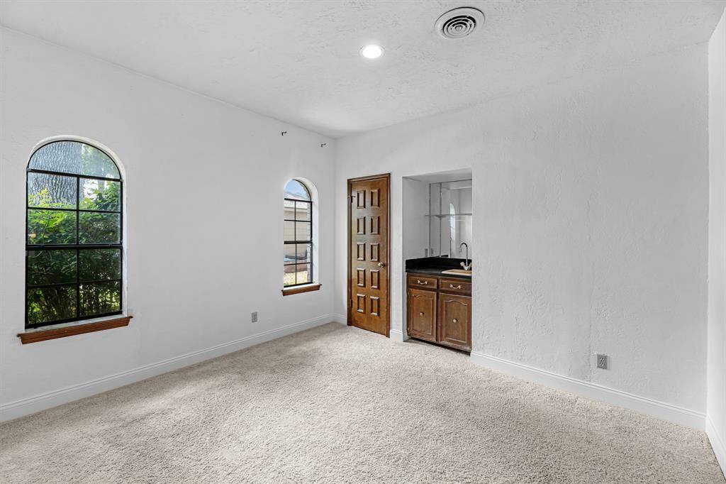 Versatile room with wet bar and natural light, great as an office or guest room.
