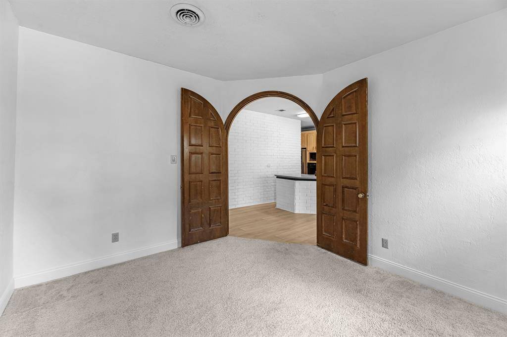 Charming arched double doors lead into the open kitchen.