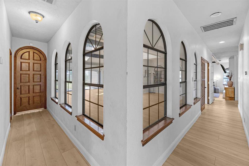 Bright hallway with unique arched windows and wood trim.