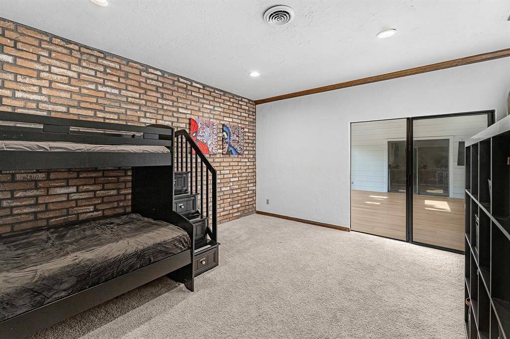 Spacious layout with sliding doors and brick accent wall.