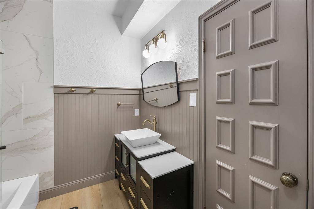 Sleek vanity with vessel sink and brushed gold fixtures.