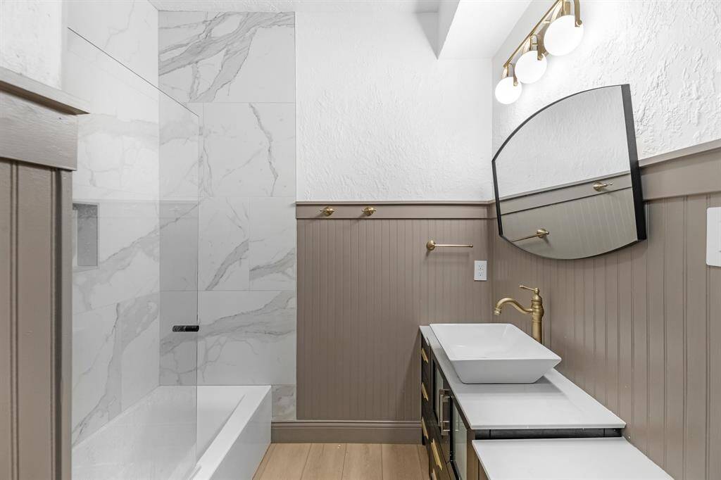 Modern bathroom with new vanity, light fixtures, and tile.
