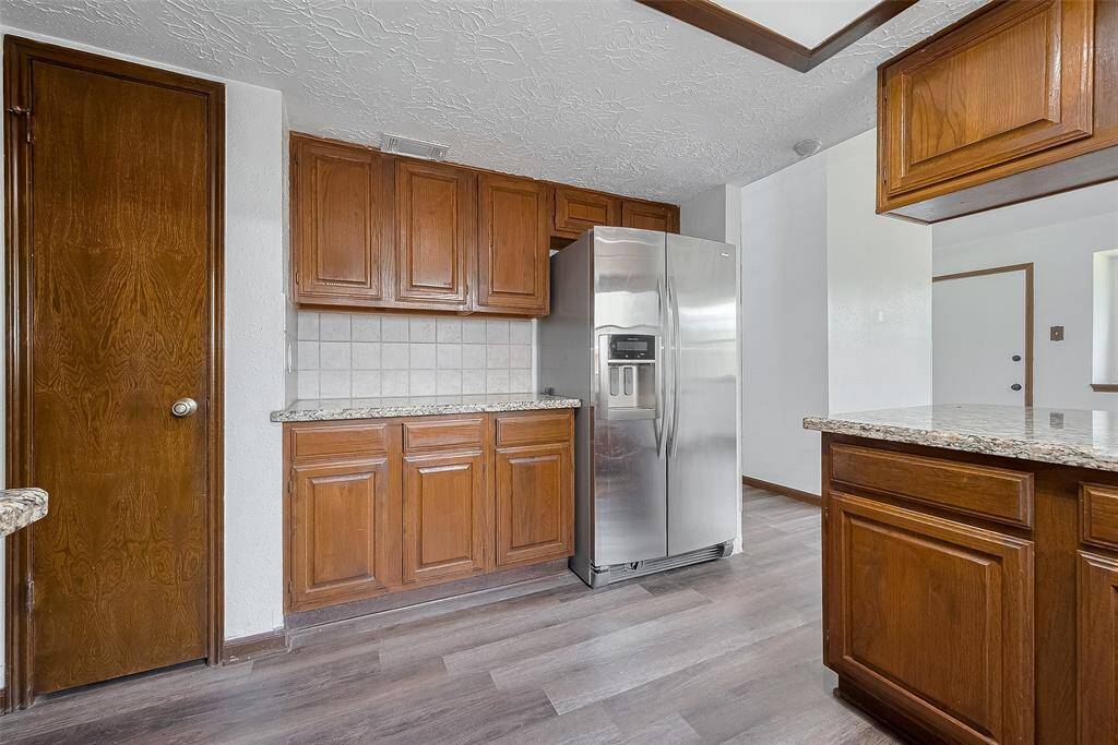Additional cabinetry and counter space across from the fridge offers even more room for storage and meal prep.