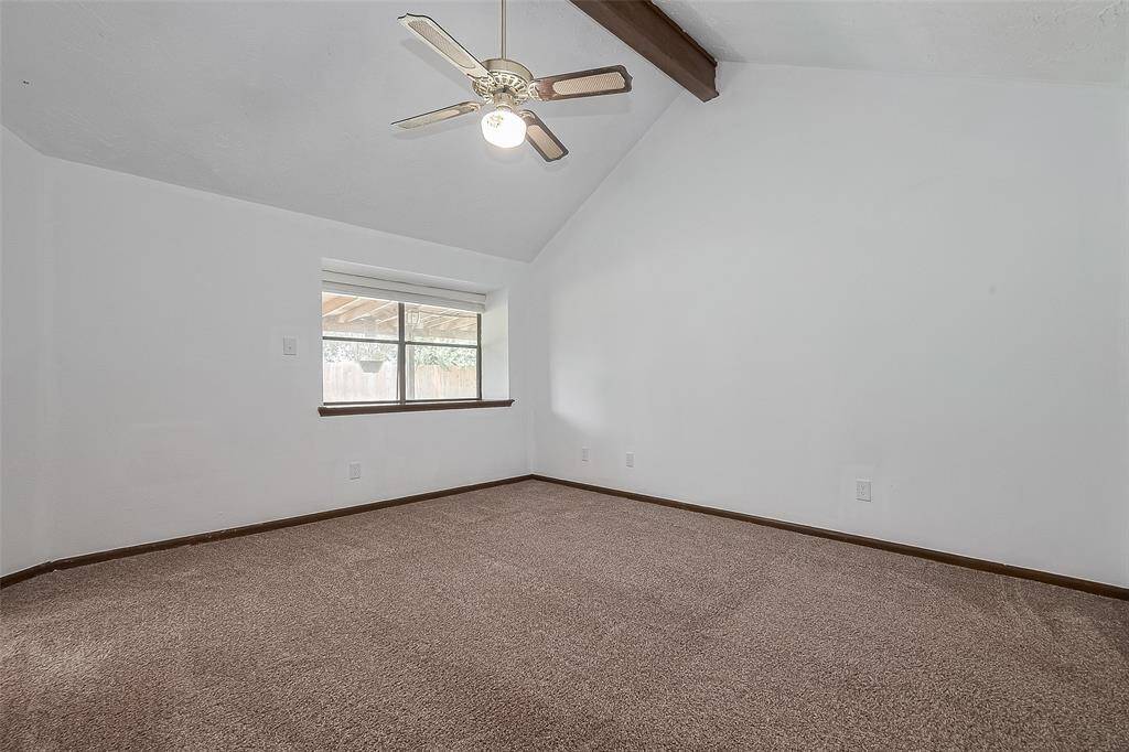A large picture window and ceiling fan make this room both bright and breezy.