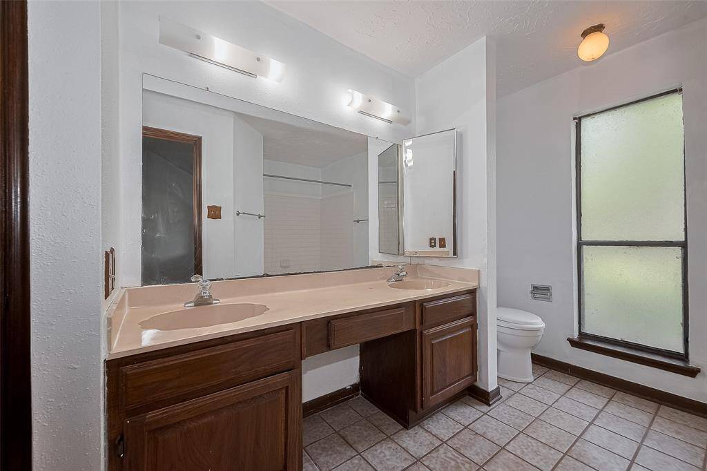 The ensuite bathroom includes dual sinks, ample counter space, and great lighting.
