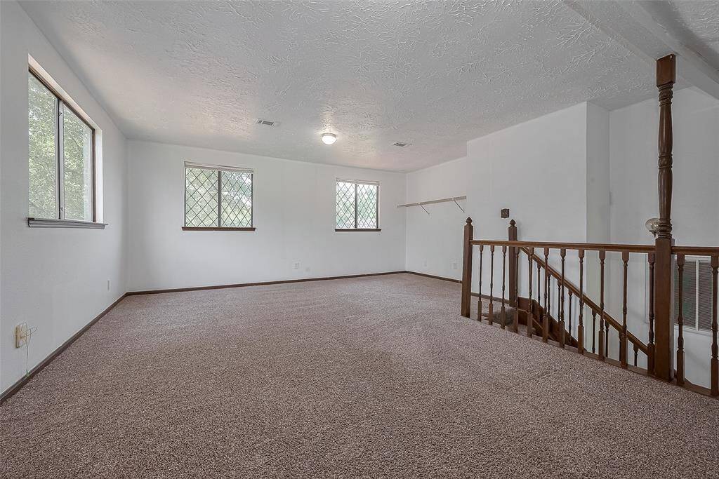 Multiple windows fill the game room with natural light while offering relaxing views of the treetops.