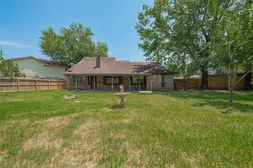 Enjoy the view of your own backyard oasis, complete with a charming fountain and a canopy of shade trees.
