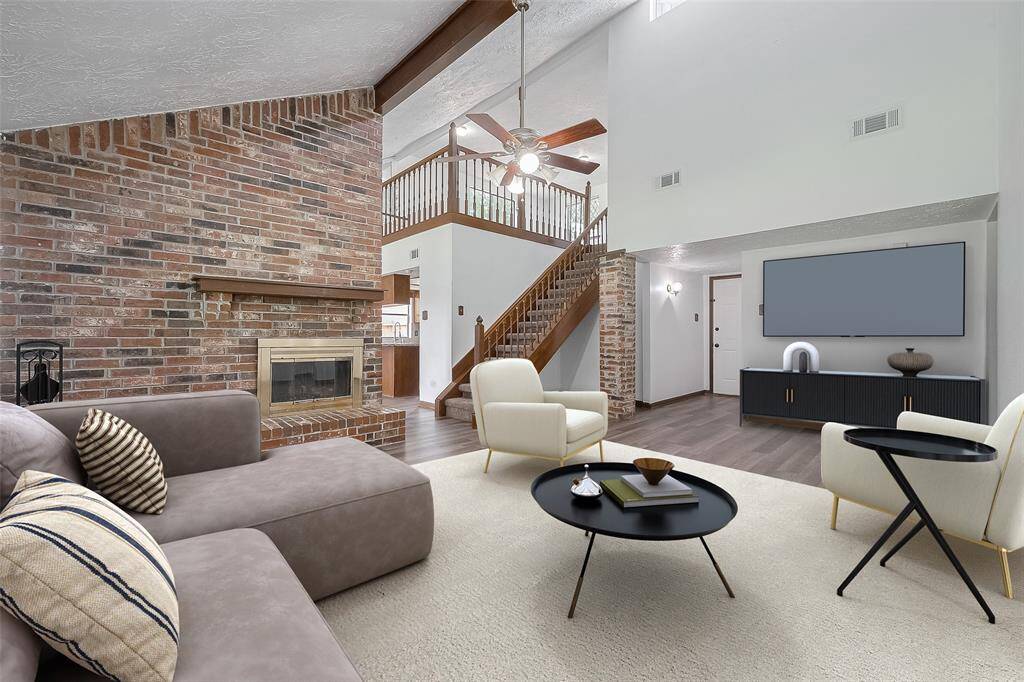 The spacious living room features a dramatic floor-to-ceiling brick fireplace that anchors the space with warmth and character.