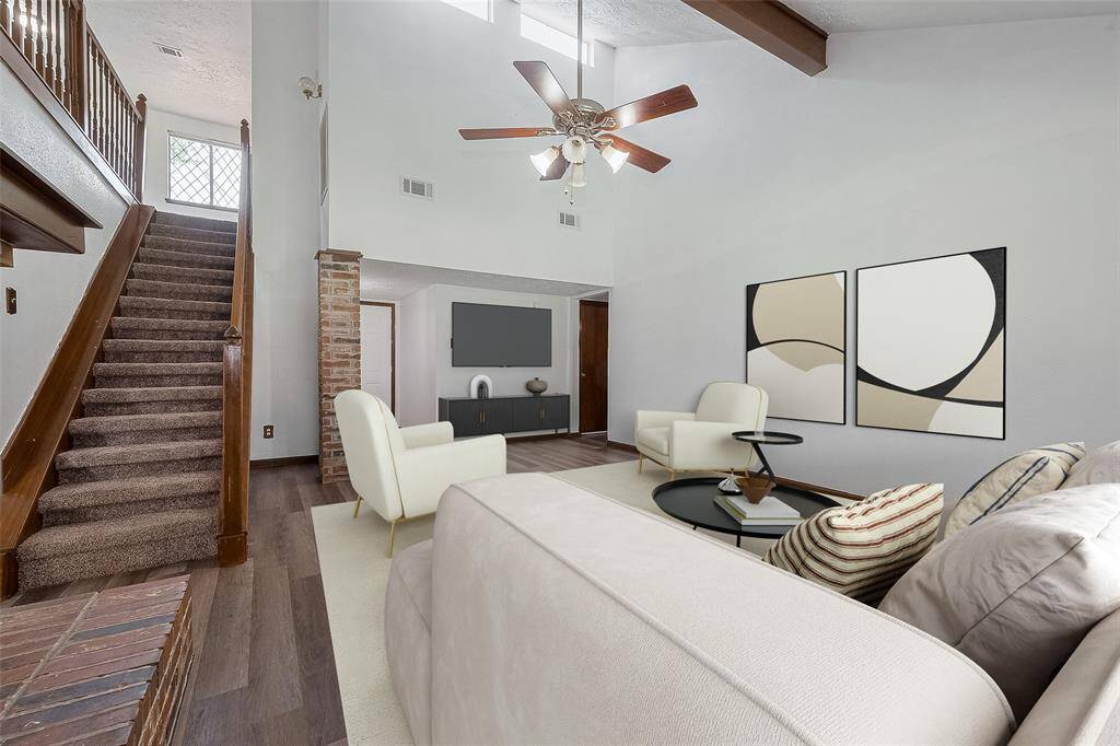 Natural light pours in from elevated windows above the staircase, adding brightness and visual interest to the main living area.