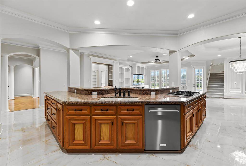 The expansive center island serves as the heart of the kitchen, featuring elegant breakfast bar seating and abundant prep space, complemented by ample additional storage to effortlessly accommodate every culinary need.