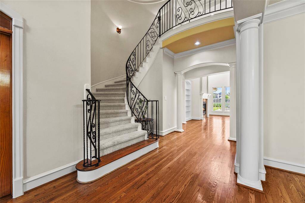 Even the staircase exudes elegance, featuring a harmonious blend of neutral hues and exquisitely crafted designer iron spindles.