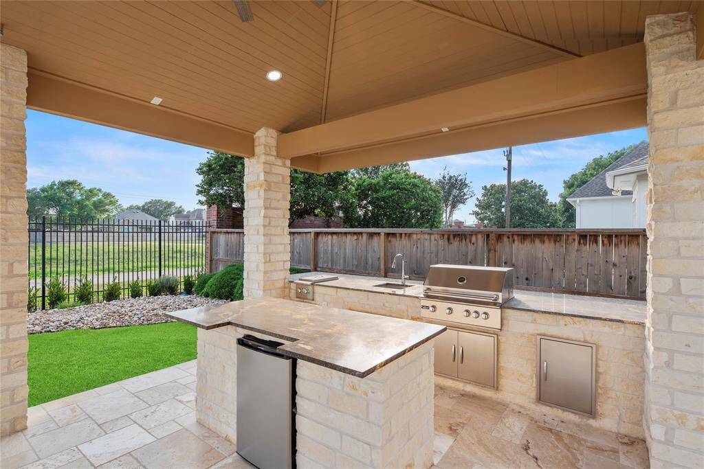 The custom outdoor kitchen is thoughtfully designed with high-end finishes and top-of-the-line appliances, making it the perfect spot to cook and entertain while enjoying the fresh air and beautiful surroundings.