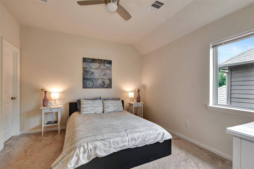 Spacious Fourth bedroom with abundant natural light from large windows. The neutral walls and carpet create a warm and relaxing atmosphere.