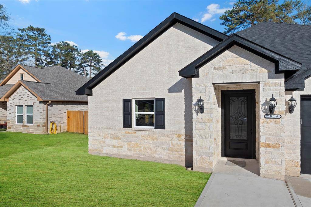 Precise brick and stonework are complimented by the sleek coach lights and a 8' wooden front door.