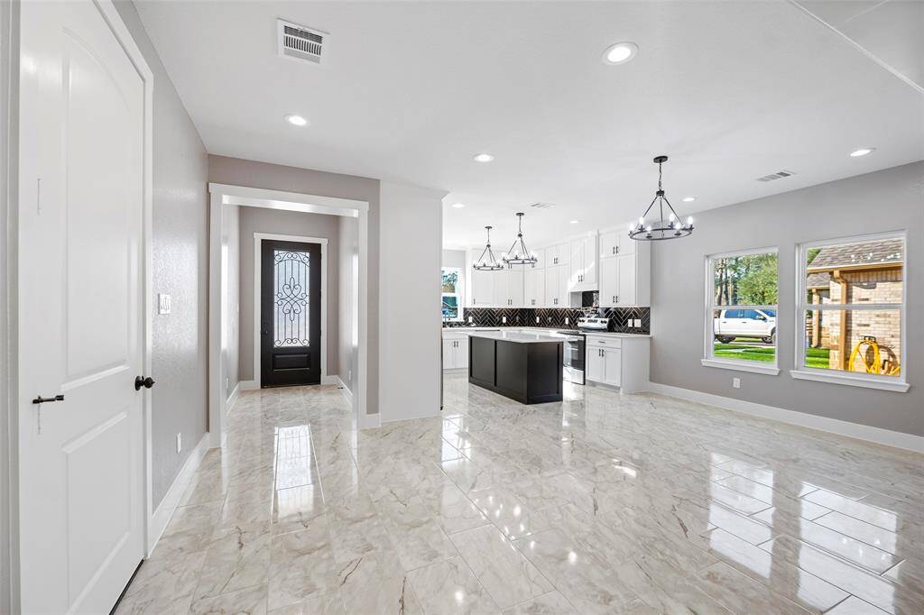 Framed archways and ample lighting will greet you as you enter this home. On your left you will get to experience an incredible kitchen and to the right is the door to the garage.