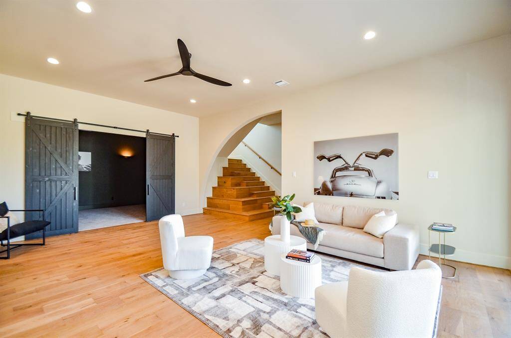 Another living area with barn doors leading to gameroom.  Stairs lead to a landing and 2 bedrooms and 2 bathrooms.