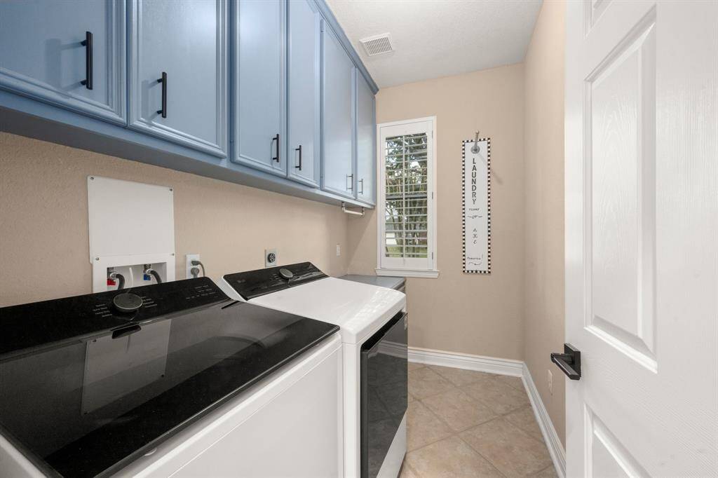 Laundry room has space for a freezer and plenty of storage.