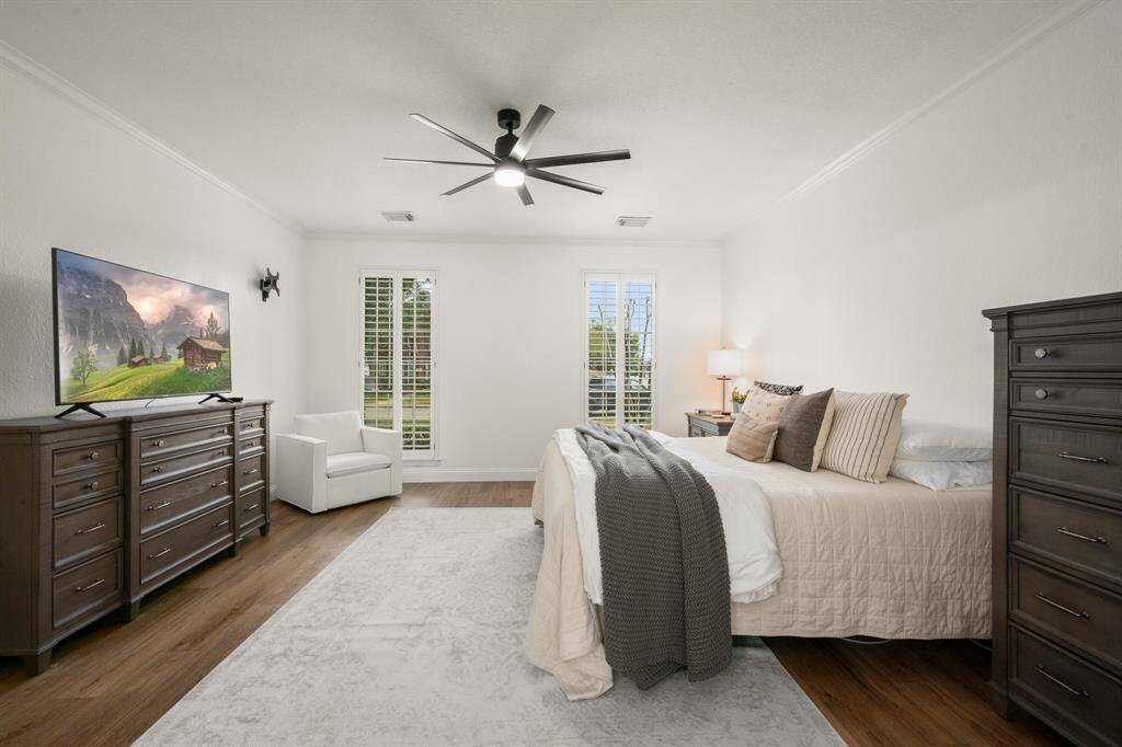Primary bedroom with new vinyl plank flooring and updated paint and fixtures.