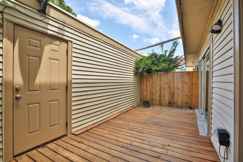 magnificent large back patio between home and garage with new deck and fence